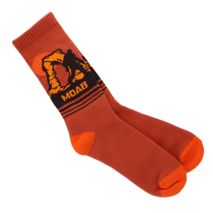 A pair of orange crew socks with a black and orange graphic on the cuff featuring the letters 'MOAB' and an off-road vehicle design, displayed on a clean white background.