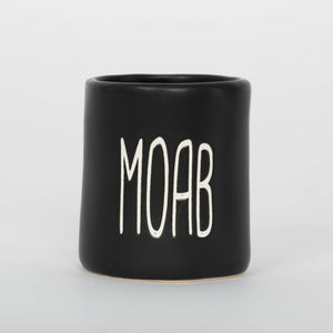 Black mug with 'MOAB' printed on a white background