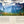 A scenic landscape poster or book page featuring a dramatic mountain valley with blue-gray peaks, green and orange forests, and a sunset sky. The lower portion has a beige parchment-style background with the heading 'INTRODUCTION' and two columns of text.