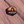 Hexagon Arches National Park enamel pin with Delicate Arch silhouetted against a yellow and orange sunset, lying on red sandstone in Moab, Utah.