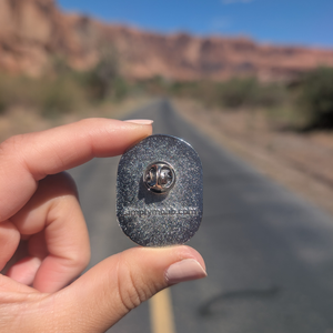 Back of the Arches National Park oval badge enamel pin showing the rubber clutch and simplymoab.com stamp.