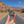 Hand holding the Arches National Park starry night enamel pin on a road through the Moab red rock cliffs.