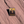 Canyonlands National Park Island in the Sky enamel pin with dark buttes against a golden sky, lying on red sandstone in Moab, Utah.