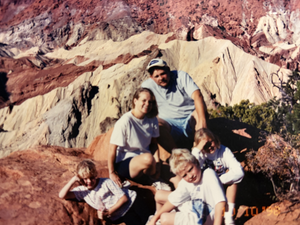 Family posing on a rocky landscape with mountains in the background