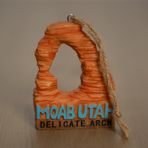 Decorative ornament shaped like Delicate Arch in Moab, Utah on a beige background