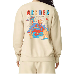 Simply Moab Arches Jimmy Crew in Ivory, a cream crewneck sweatshirt with the retro alien and bigfoot Arches graphic on the back, worn by a model