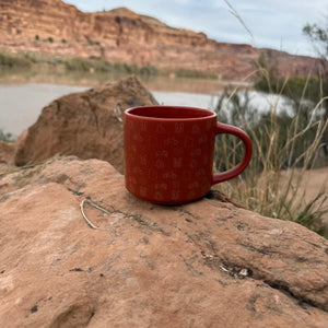 Smith-Western Icon Pop Ceramic Mug on red sandstone by the Colorado River near Moab