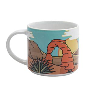 Smith-Western Into the Desert Ceramic Mug, a teal mug with an illustrated Delicate Arch and desert plants, arch side